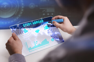 Business, Technology, Internet and network concept. Young businessman working on a virtual screen of the future and sees the inscription: Study abroad