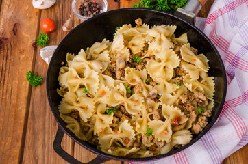 Pasta farfalle with fried meat, mushrooms and vegetables