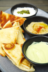 Grilled flatbread with spreads: creamy avocado, chickpea hummus and whipped ricotta