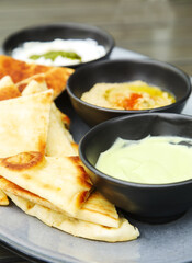 Grilled flatbread with spreads: creamy avocado, chickpea hummus and whipped ricotta