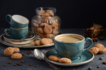 Cup of fresh coffee with Amaretti cookies on dark background, selective focus