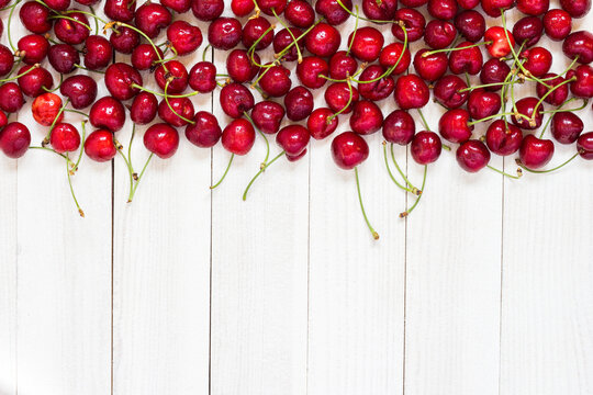 Red cherries on white wooden background