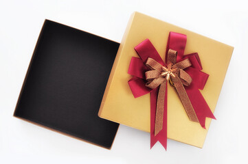 Top view of yellow open gift box with red ribbon on white background, holiday and event concept