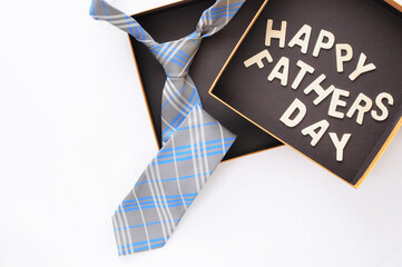 Necktie and wooden of happy fathers day words is in gift box on white background, business concept and holiday and event idea