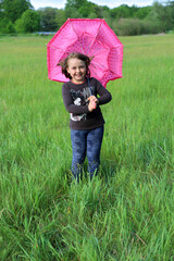 Śliczna dziewczynka z parasolką porwaną przez wiatr.