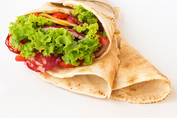Roll tortilla with herbs, cheese and meat on a white background.