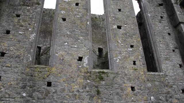 Pan Down of Wall of Rock of Cashel with Crows Flying