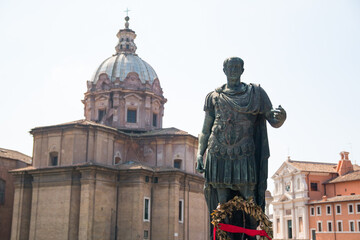 Obraz premium Bronze statue of emperor Julius Caesar over Temple of Venus Genetrix in Rome