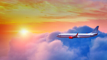 Fototapeta na wymiar Airplane flying above clouds in sunset light.