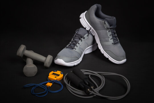 Sport shoes dumbbells skipping rope and digital stopwatch
