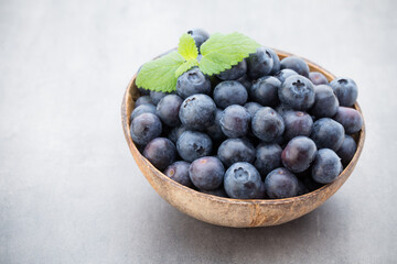 Fresh blueberries natural coconut in a bowl on a gray background.