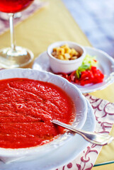 Cold Spanish gazpacho soup made of wiped tomatoes and vegetables in a white plate.