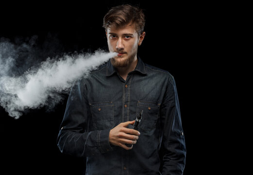 vaping man holding a mod. A cloud of vapor.