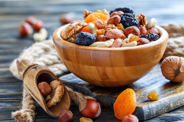Wooden bowl with nuts and dried fruits. - obrazy, fototapety, plakaty