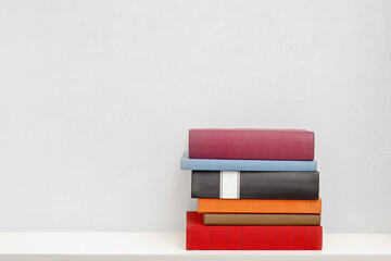stack of new colorful books in the white bookself - 157582716