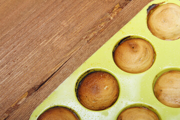 Sweet muffins on wooden background baked in silicone form.