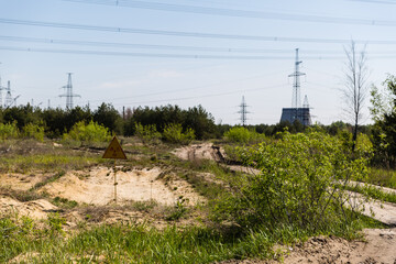 radioactive warning sign in front of chernobyl cooling towers
