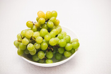 Green grape on plate on white background