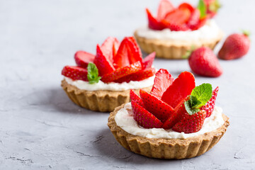 Strawberry vanilla cream cheese tarts over light gray table - obrazy, fototapety, plakaty