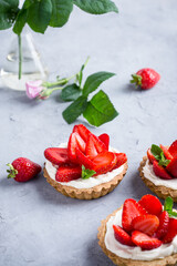 Strawberry vanilla cream cheese tarts over light gray table