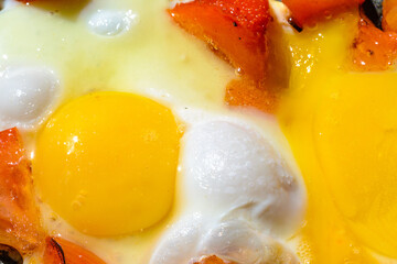 Scrambled eggs with roasted tomatoes/Scrambled eggs with tomato in a frying pan. The process of preparing breakfast