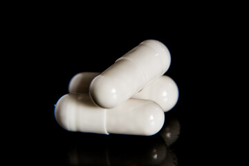White capsules on a black background.