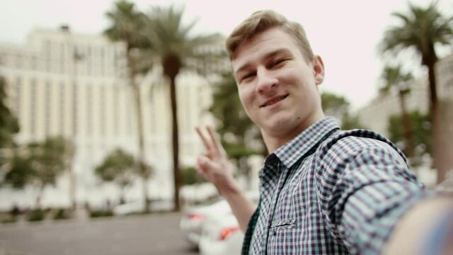 Classy guy is looking at the camera and waving his hand