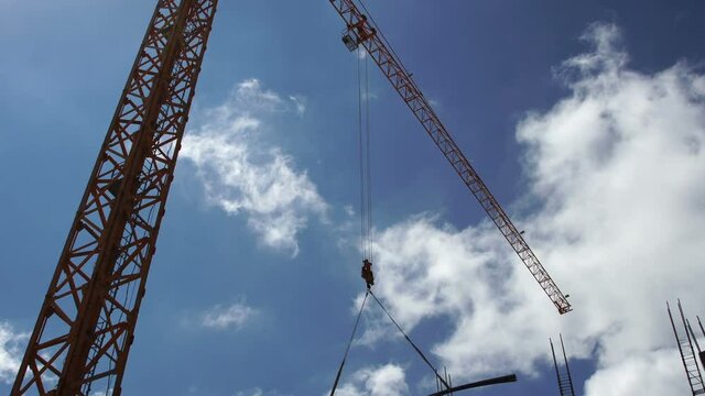 Construction site. Construction crane lifts cargo against the blue sky