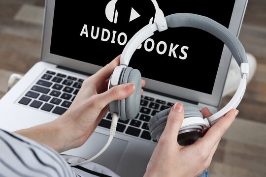 Concept of audio books and modern technology. Woman using laptop and headphones, closeup