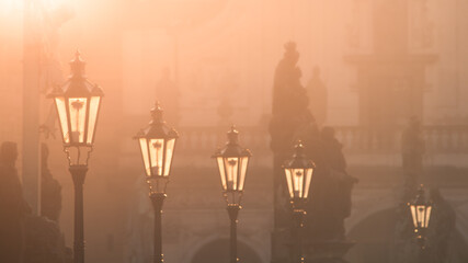 Street lamps on Charles bridge illuminated by sun in the morning, Old Town, Prague, Czech Republic.