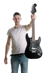 Music and creativity. A handsome young man in a T-shirt holds out an electric guitar in his hand. Play it. Horizontal frame