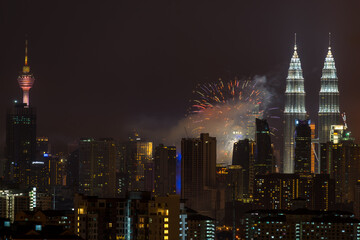 Fototapeta na wymiar Fireworks explode near Malaysia's landmark Petronas Twin Towers during Independence Day celebrations in Kuala Lumpur.