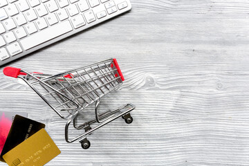 buying products with cards and mini trolley light table background top view space for text