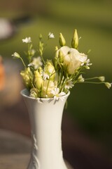 white flowers at vase on wooden table