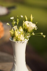 white flowers at vase on wooden table