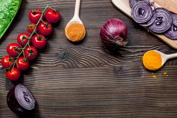 paella ingredients with onion, spices and tomatoes on wooden table background top view mock up
