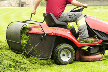 Fototapeta na wymiar mower lawnmower and gardener cutting the grass