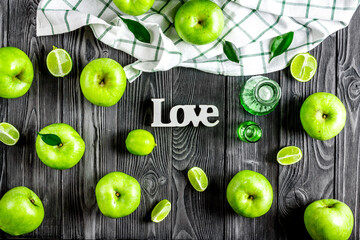 Fototapeta na wymiar ripe green apples with love dark wooden table background top view pattern