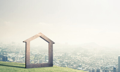 Conceptual image of concrete home sign on hill and natural lands