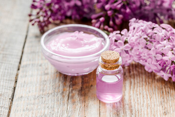 Obraz na płótnie Canvas lilac natural cosmetic set for spa with oil wooden table background
