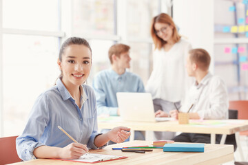 Beautiful young woman working in office