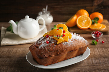 Plate with delicious yogurt cake and citrus fruit on wooden table