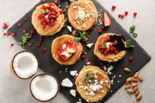 Slate plate with stacks of delicious coconut pancakes on textured background