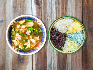 Cooked rice in bowl with Thai food on wood background.