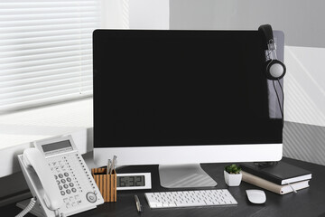 Modern comfortable workplace with computer and window blinds