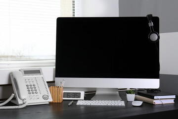 Modern comfortable workplace with computer and window blinds