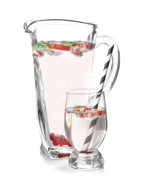 Jug and glass of refreshing lemonade on white background