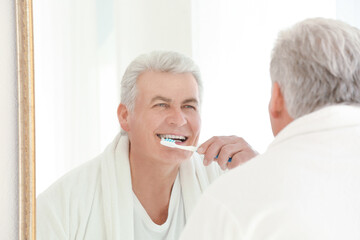 Senior man cleaning teeth at home