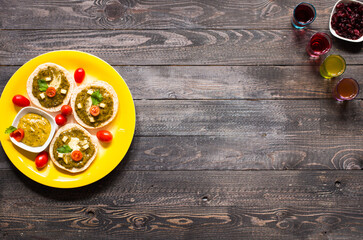 Fototapeta na wymiar tasty and delicious bruschetta with avocado, tomatoes, cheese, herbs, chips and liquor, on a wooden background.