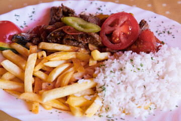 Traditional Hungarian goulash with rice, french fries and pepper close up